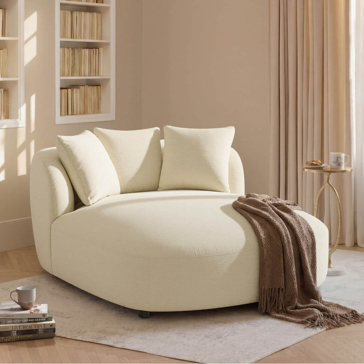 Gabriel modern curved chaise lounge accent chair in cream textured fabric with plush pillows.