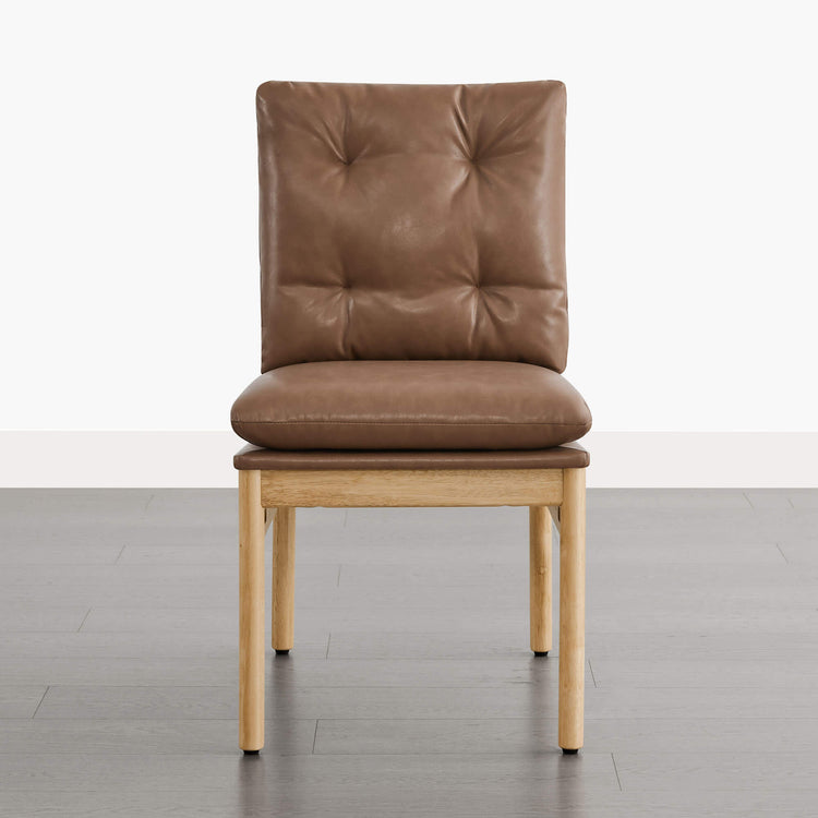 Flynn mid-century tufted plush dining chair in saddle brown faux leather with a light wood frame.
