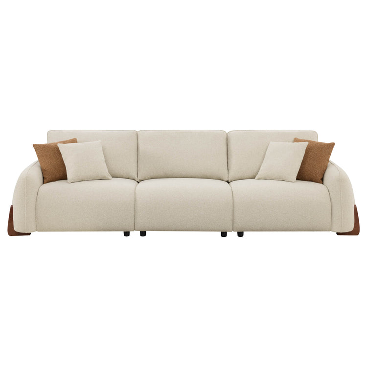 Teleri 3-seat modular curved sofa in sand color with curved wood legs and two decorative pillows.
