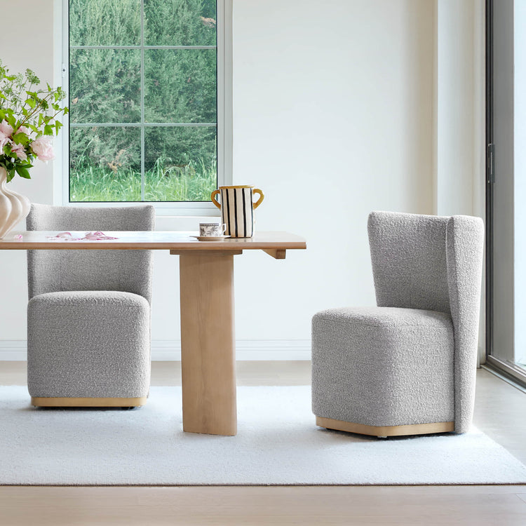 Gray upholstered wingback chairs with wooden bases at a minimalistic dining table - CHITA Living