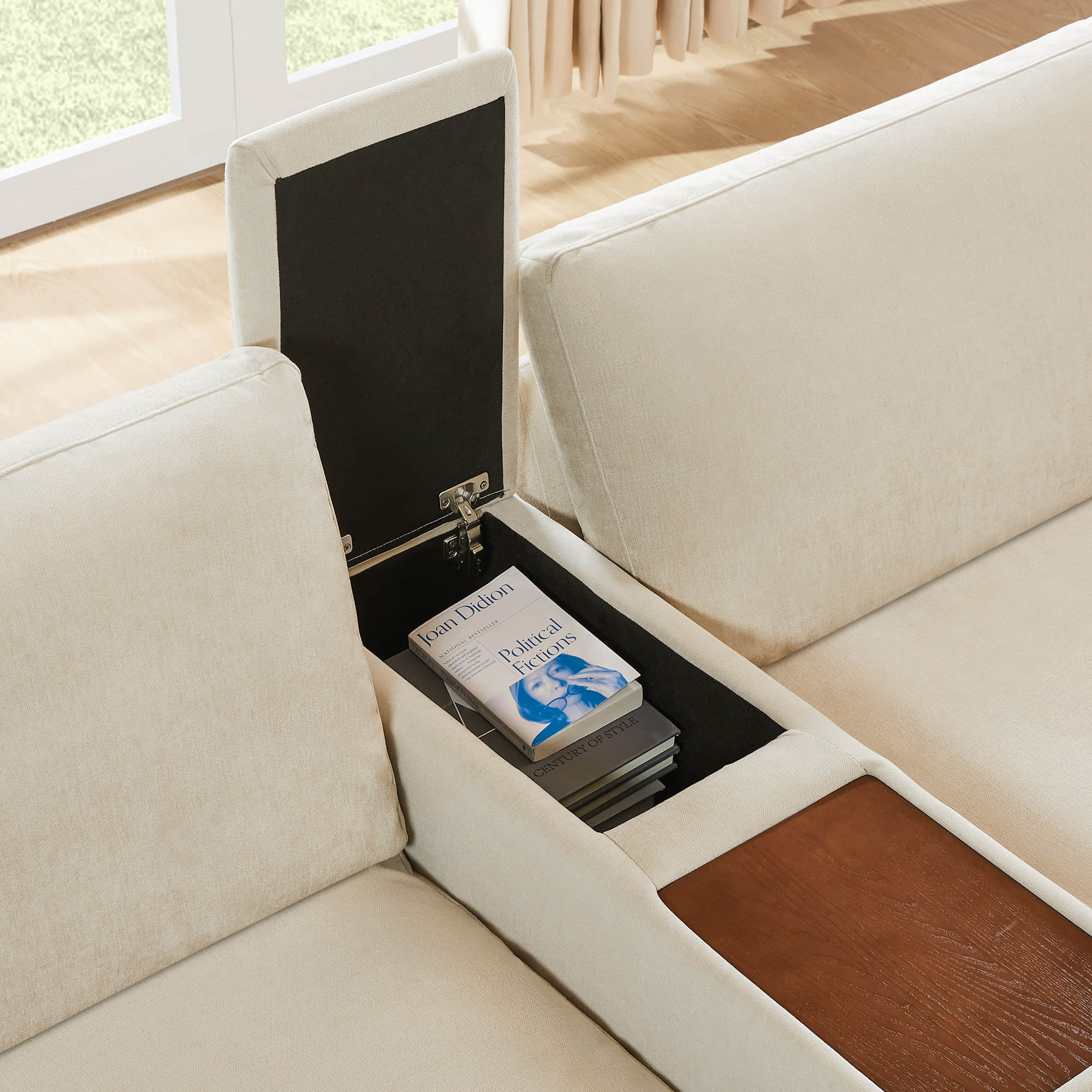 CHITA Kenna Sofa in beige with lift-top console and wooden armrest, featuring "Political Fictions" book.