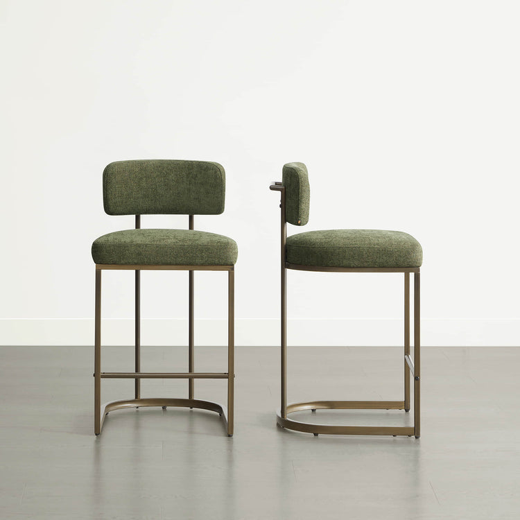 Two green kitchen barstools, varied heights, sleek metal frames.
