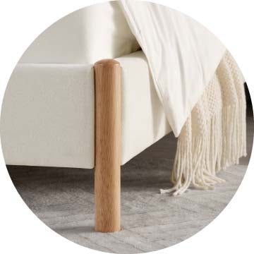Close-up of cream upholstered bed leg highlighting natural wood accent - CHITA Living