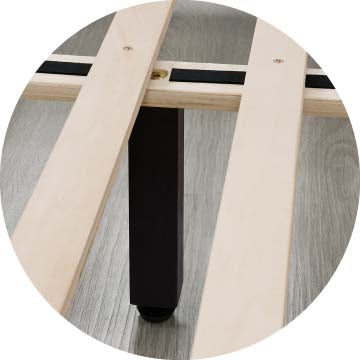 Close-up of queen-size bed frame slats and black support leg on wooden floor - CHITA Living