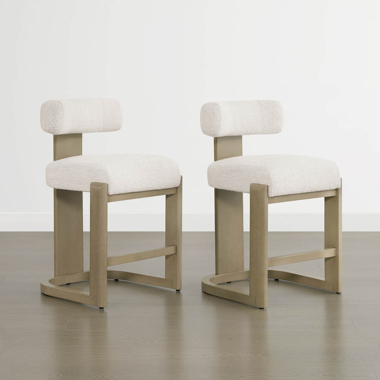 Troy Boucle Counter Stools with solid wood frames and cream bouclé upholstery offer elegant, modern seating options.