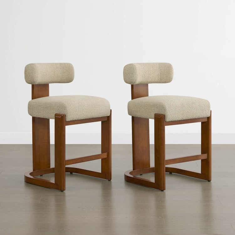 Troy Boucle Counter Stools with solid wood frames and cream bouclé upholstery offer stylish, modern seating.