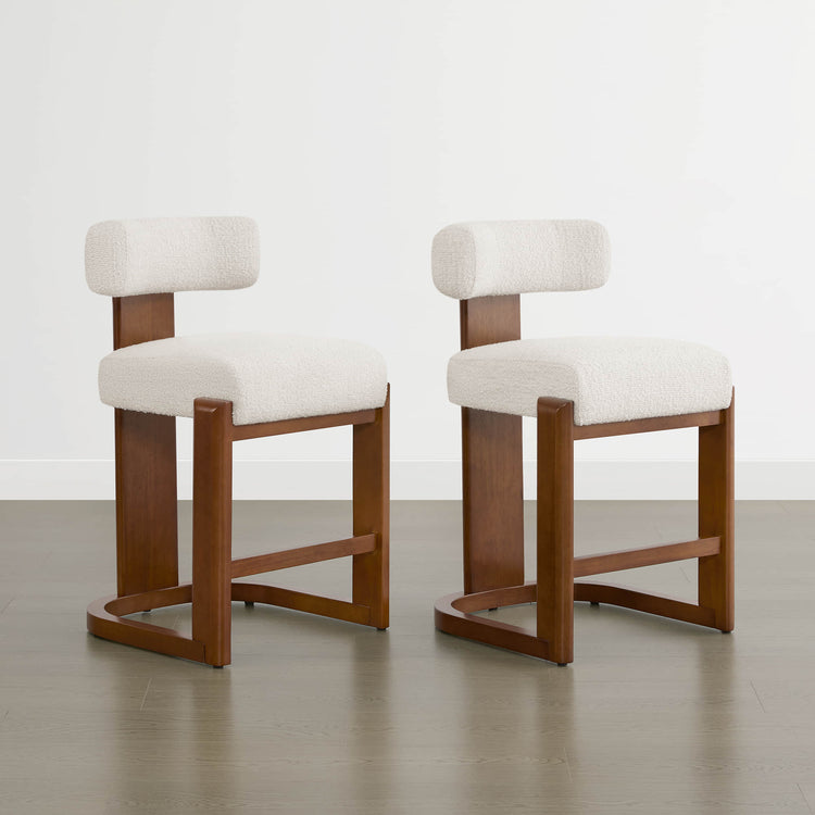 Troy Boucle Counter Stools feature solid wood frames and cream bouclé upholstery, providing modern and elegant seating.