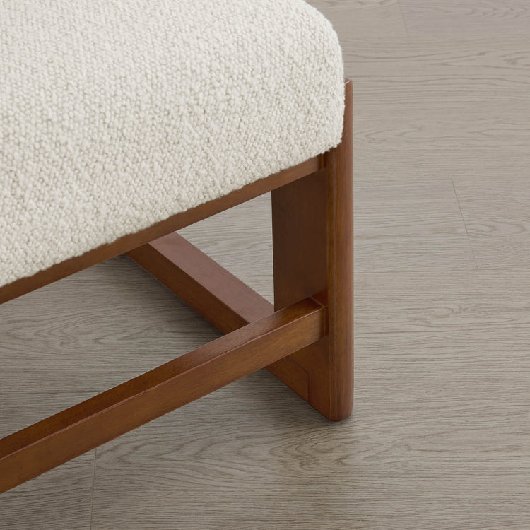 The Troy Boucle Dining Chair features a creamy bouclé seat and sturdy solid wood legs with a sleek, modern design.