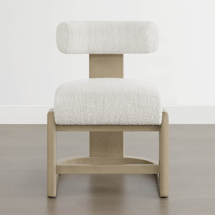 The Troy Boucle Dining Chair features a modern design with solid wood legs and a plush, textured bouclé fabric seat and backrest.