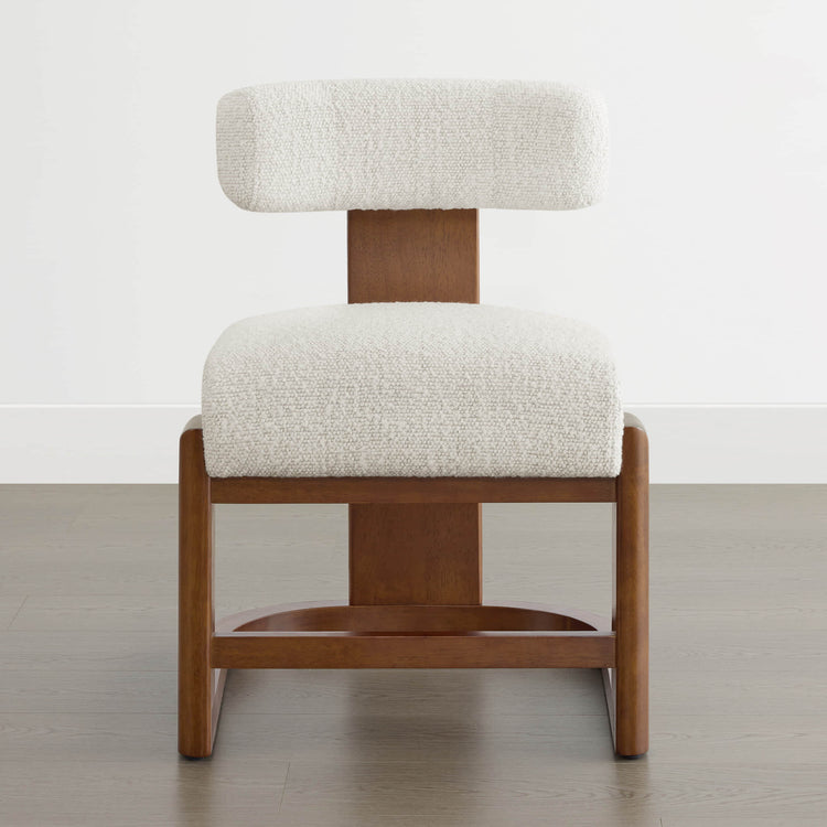 The Troy Boucle Dining Chair features a plush white bouclé fabric seat and backrest with sturdy, polished solid wood legs.