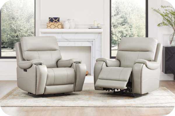 Two light gray recliners in a living room, one fully reclined