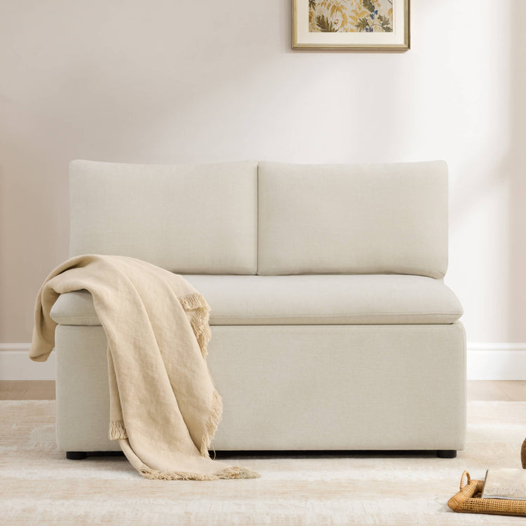 Lila minimalist beige linen dining banquette bench with built-in storage and a draped throw blanket.