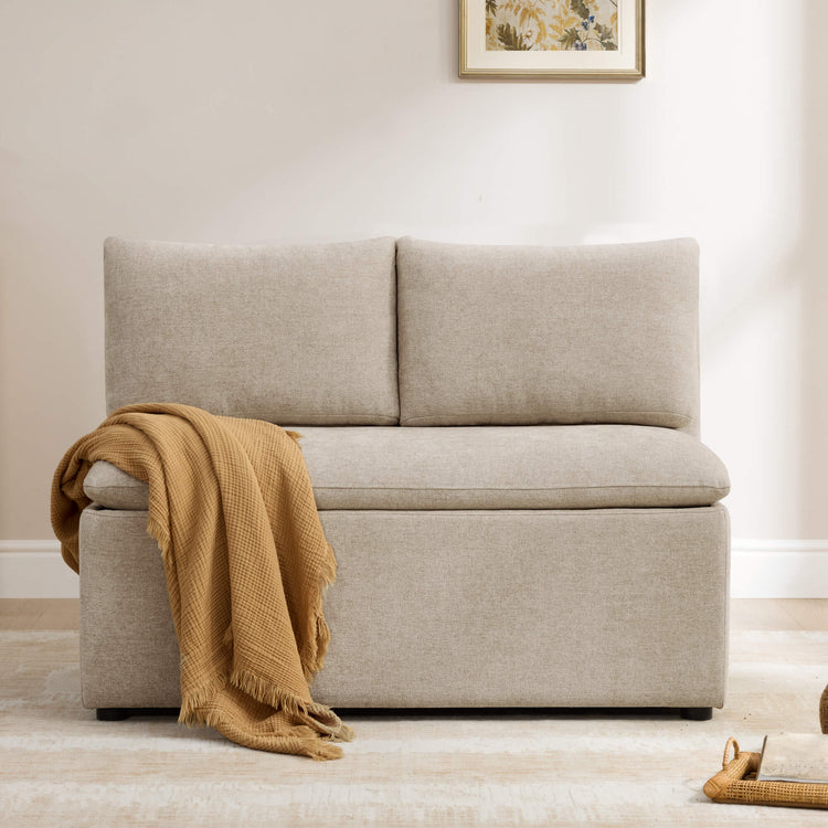 Lila minimalist beige linen dining banquette with storage. Features plush cushions and a mustard throw.