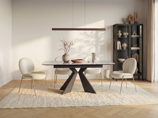 A modern dining room with a rectangular sintered stone table on a dark sculptural X-base, surrounded by four cream bouclé chairs, a linear pendant light, and a tall black display cabinet.