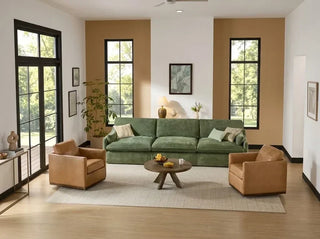 Green sofa and two tan leather armchairs around a wood coffee table in a bright living room.