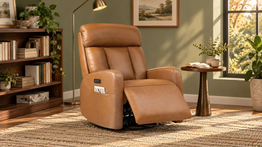 Tan Maxwell recliner with an open footrest beside a bookcase, reading lamp, and side table.