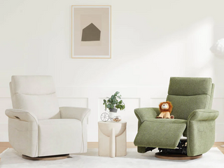 Two modern nursery power swivel gliders side by side—one upright in off-white fabric and the other reclined in olive green fabric with a stuffed lion toy on the seat.