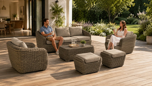 Liana Wicker Outdoor 5 Seats Sofa Set on a sunlit wooden deck with beige cushions, coffee table, ottomans, and two people relaxing in a garden patio.