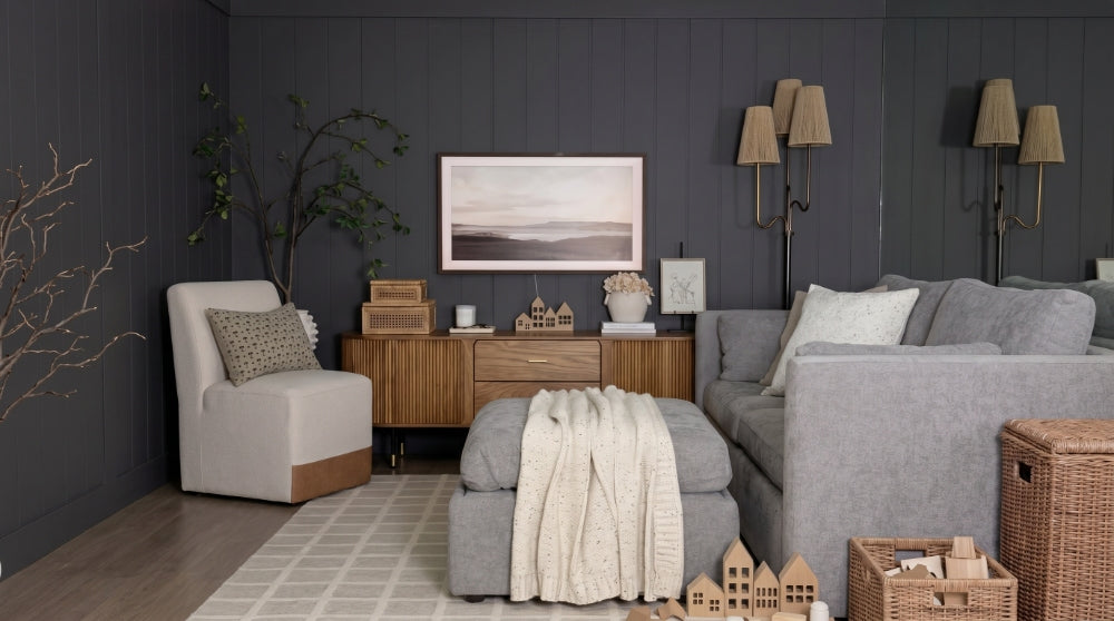 A beautifully styled kids' playroom featuring a light gray Delaney modular sofa, a storage ottoman, a wooden console, and a comfortable Aida chair against a dark gray accent wall.