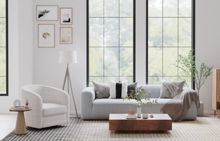 Tall black-framed windows and wall art suggest open-plan room sightlines, highlighting why sofa placement mistakes can disrupt natural light and visual flow in living spaces