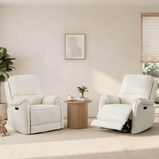 Two ivory power recliners sit beside a round wood table in a sunlit living room with plants, blinds, and soft neutral decor.