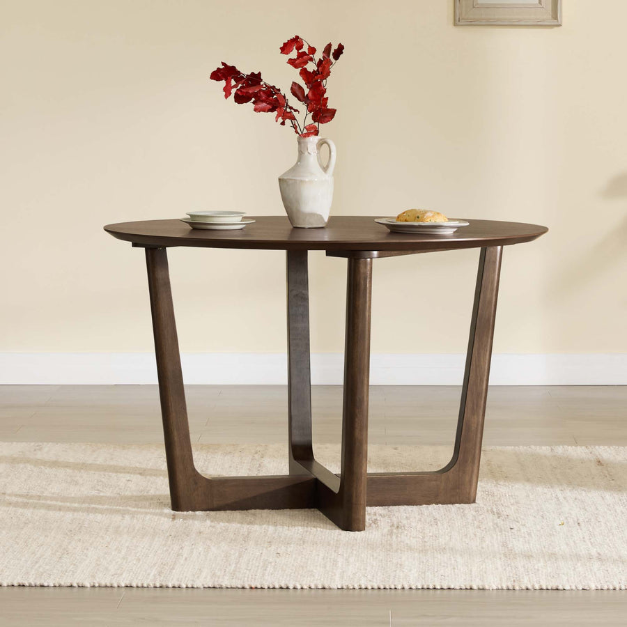 A round four-person dining table provides a visual contrast to the compact two-person bistro-table footprint discussed in the article.