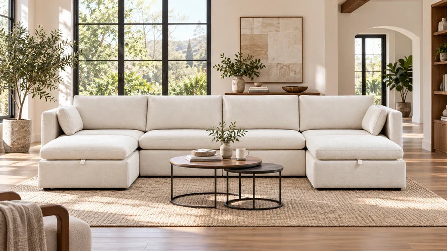 Cream Delaney modular sectional with two ottomans in an open living room.