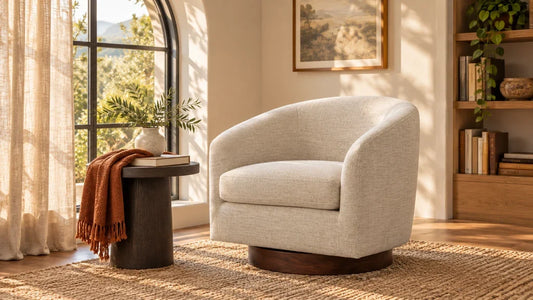 Beige barrel swivel chair with a wood base beside a small table and arched window.