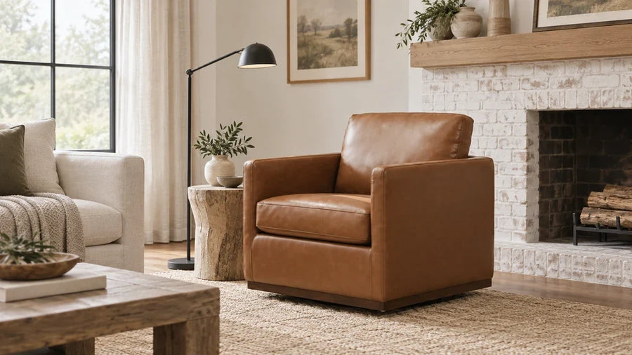 Cognac leather accent chair with a dark wood base beside a whitewashed brick fireplace.