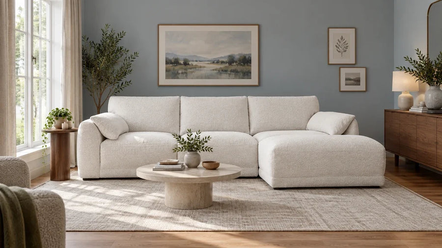 Ivory boucle sectional with a right chaise in a compact blue-gray living room.