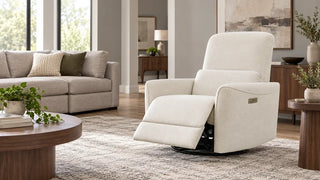 Cream recliner with its footrest extended and a gray sofa in the background.