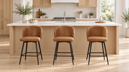 Three cognac upholstered stools evenly spaced beside a long white kitchen island.
