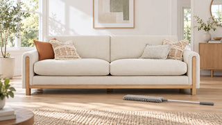 Ivory Keaton sofa with an ash wood base and a flat duster on the floor