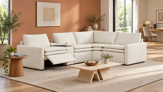 White Ohana reclining sofa with a closed laptop on a side table and a separate desk behind it.