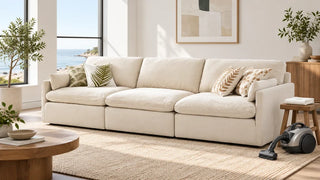 Cream Kenna sofa with a vacuum and folded cleaning cloth beside it.