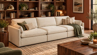 Cream Kenna deep-seat sofa beside walnut shelving in a reading room.