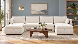 A white Delaney sectional with ottomans at both ends in a blue-grey living room