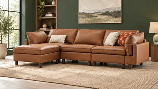 A tan Brendon sectional with its wooden legs visible in a green-walled room