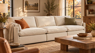 Cream Kenna sofa with rust and olive pillows and an oatmeal throw in a fall living room.