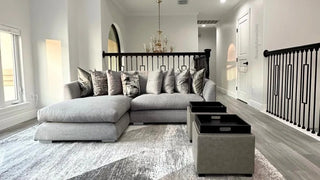A gray sectional with two tray-topped ottomans in a home seating area.