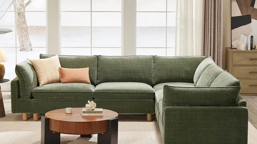 Green sectional sofa in a bright living room.