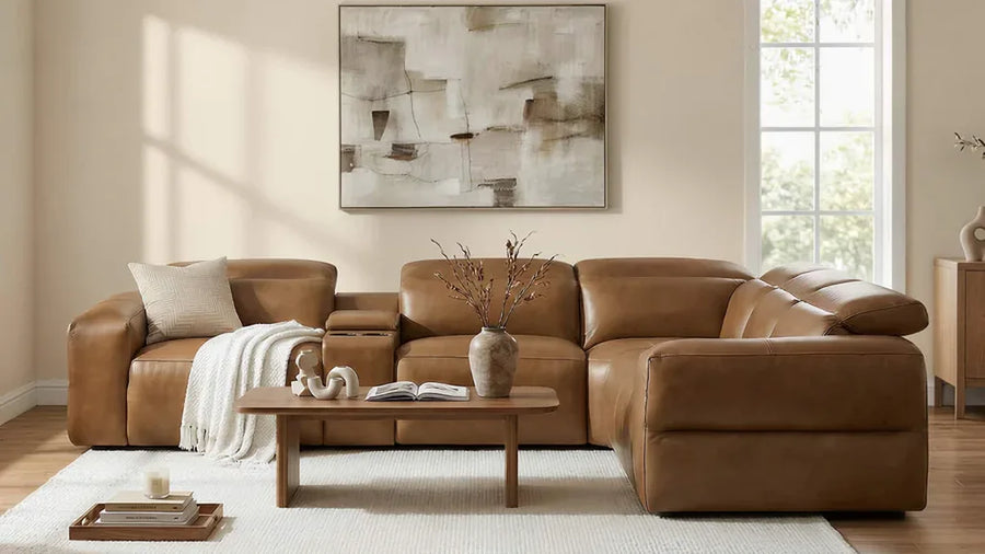 Brown leather sectional with a chaise in a sunlit living room.