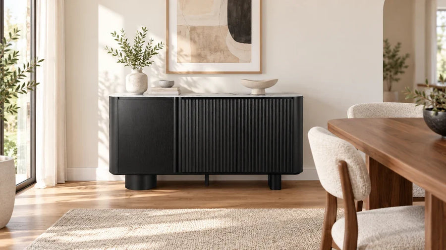 Black fluted Rex sideboard beside a wooden dining table in a sunlit room