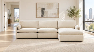 Cream sectional with its chaise on the viewer's right and an open walkway to the left.