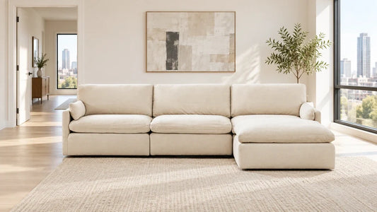 Cream sectional with its chaise on the viewer's right and an open walkway to the left.