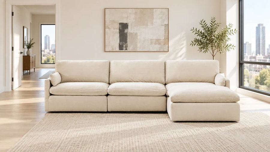 Cream sectional with its chaise on the viewer's right and an open walkway to the left.