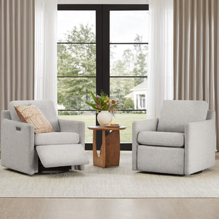 Two swivel recliner chairs in a bright living room with a large window.
