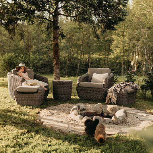  A family relaxes in a garden on CHITALIVING chairs with their dogs.