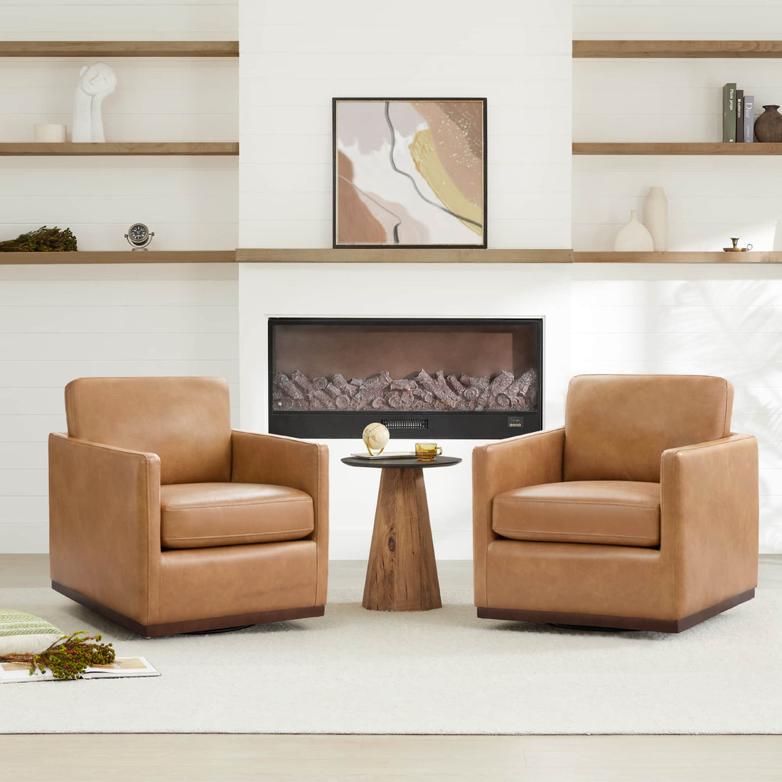Two tan leather accent chairs positioned near fireplace creating intimate conversation area with round side table in modern living room