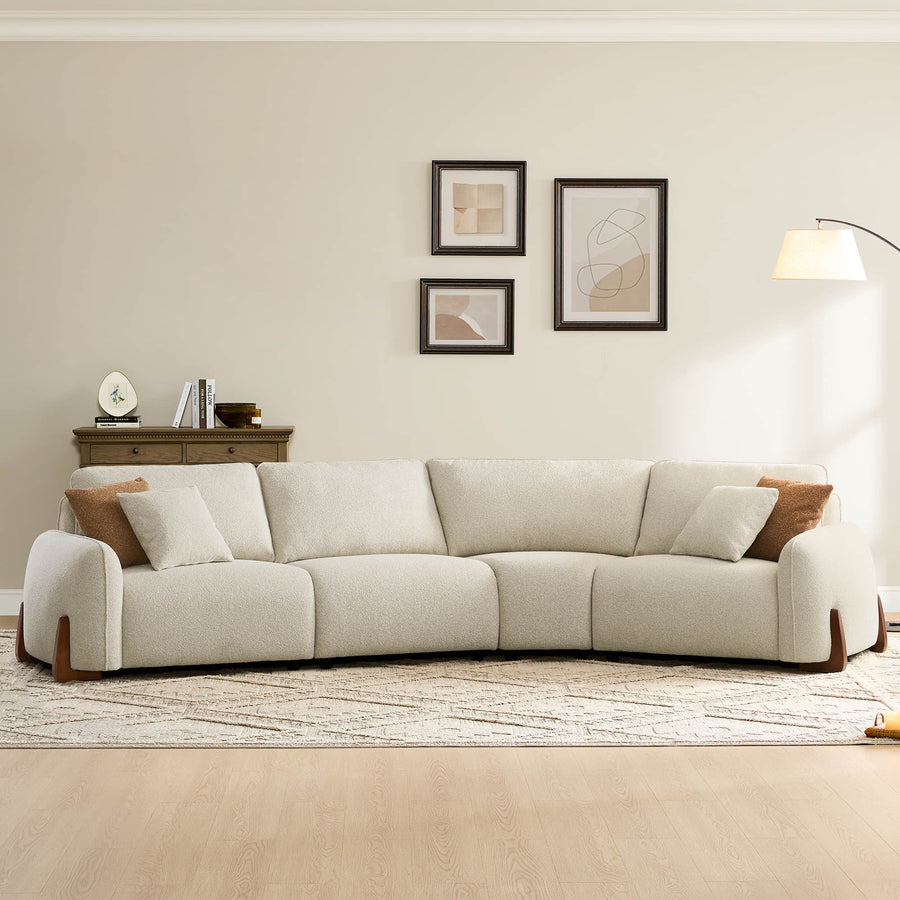 Beige sectional sofa with wooden legs in a minimalist living room with framed art and soft lighting.